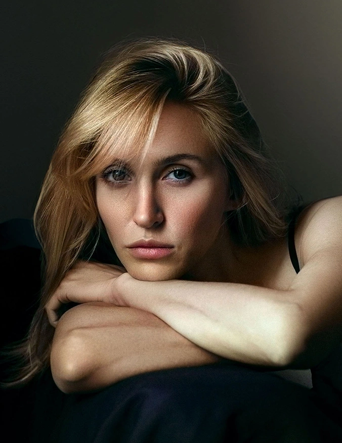 A striking portrait of a woman with blonde hair resting her chin on her crossed arms, looking forward with a focused gaze. The lighting highlights her clear, even skin tone and refined facial features. - Nano infusion therapy in Tampa, FL